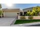 Tan stucco house with a two-car garage and well-manicured lawn at 8100 E Camelback Rd # 14, Scottsdale, AZ 85251