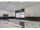 Modern kitchen with white cabinets, marble countertops, and dark-colored island at 8641 E Fillmore St, Scottsdale, AZ 85257