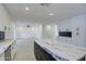 Modern kitchen with white cabinets, marble countertops and island, open to adjacent living area at 8641 E Fillmore St, Scottsdale, AZ 85257