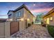 Elegant home exterior with a paved pathway, wrought iron gate, and string lights at 8793 W Villa Lindo Dr, Peoria, AZ 85383