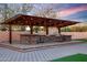 Stunning outdoor kitchen with a pergola, built-in grill, and bar area at 8793 W Villa Lindo Dr, Peoria, AZ 85383