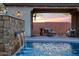 Relaxing pool area with a stone water wall and comfortable seating at 8793 W Villa Lindo Dr, Peoria, AZ 85383