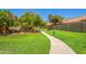 Paved pathway winds through grassy area with mature trees and benches at 9030 S Maple Ave, Tempe, AZ 85284