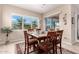 Bright dining room featuring a wood table and chairs, with large windows offering backyard views at 9364 W Cashman Dr, Peoria, AZ 85383