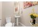 Small powder room with pedestal sink, toilet, and decorative wall art at 9364 W Cashman Dr, Peoria, AZ 85383