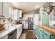 Beautiful kitchen featuring a farmhouse sink, stainless steel appliances, and a green kitchen island at 9713 E Onza Ave, Mesa, AZ 85212