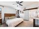 Spacious main bedroom with a wooden accent headboard and a stylish sliding barn door to the bathroom at 9713 E Onza Ave, Mesa, AZ 85212