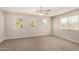 Bright bedroom with neutral walls, carpeting, and three windows at 106 N 66Th Ave, Phoenix, AZ 85043