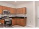 Kitchen with wood cabinets, granite counters, and stainless appliances at 106 N 66Th Ave, Phoenix, AZ 85043