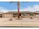 Single-story home with a landscaped front yard, a two-car garage, and palm trees at 10906 W Tropicana Cir, Sun City, AZ 85351