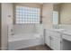 Bathroom boasts a soaking tub, vanity with double sinks, and a block glass window at 1116 W Courtney Ln, Tempe, AZ 85284