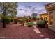 Landscaped backyard with a patio, artificial grass, and desert landscaping at 13286 W Micheltorena Ct, Sun City West, AZ 85375