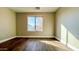 Bright bedroom with large window, hardwood floor, and neutral walls at 15058 W Fillmore St, Goodyear, AZ 85338