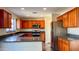 L-shaped kitchen with wood cabinets and dark countertops at 15058 W Fillmore St, Goodyear, AZ 85338