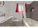 Clean bathroom with gray tile, bathtub, and red curtains at 1561 W 5Th St, Mesa, AZ 85201