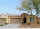 Tan colored house with a tile roof, two-car garage, and desert landscaping at 16918 W Palm Ln, Goodyear, AZ 85395