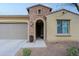 Front entrance of a tan house with arched entryway and brick detailing at 16918 W Palm Ln, Goodyear, AZ 85395