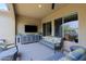 Covered patio with comfortable seating and a large TV at 16918 W Palm Ln, Goodyear, AZ 85395