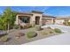 Tan three-car garage home with desert landscaping and stone accents at 19684 N 260Th Ave, Buckeye, AZ 85396