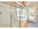 Bright bathroom featuring a glass shower and separate soaking tub with natural light at 22852 N 103Rd Ave, Peoria, AZ 85383