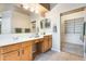 Bathroom with double sinks, vanity, wooden cabinets and walk-in closet at 22852 N 103Rd Ave, Peoria, AZ 85383