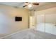 Bedroom featuring carpet, a TV, ceiling fan, closet, and a connecting door at 22852 N 103Rd Ave, Peoria, AZ 85383