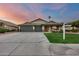 Charming single-story home with a three-car garage, lush lawn, and desert landscaping at 22852 N 103Rd Ave, Peoria, AZ 85383