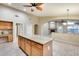 Spacious open kitchen with a granite island, tile flooring, and adjacent living area at 22852 N 103Rd Ave, Peoria, AZ 85383