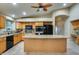 Spacious kitchen featuring a large island, granite countertops, wood cabinets, and modern appliances at 22852 N 103Rd Ave, Peoria, AZ 85383