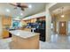 Updated kitchen with granite island, stainless appliances, wood cabinets, and ceiling fan at 22852 N 103Rd Ave, Peoria, AZ 85383