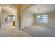 Open-concept living room with plush carpeting, neutral walls, and arched entryway at 22852 N 103Rd Ave, Peoria, AZ 85383