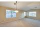 Spacious living room with neutral carpet and paint, vaulted ceiling, and bright windows at 22852 N 103Rd Ave, Peoria, AZ 85383