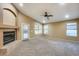 Cozy living room with a fireplace, ceiling fan, neutral carpet, and access to the backyard at 22852 N 103Rd Ave, Peoria, AZ 85383