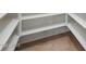 Walk-in pantry with white shelving and tile flooring at 22852 N 103Rd Ave, Peoria, AZ 85383