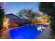 Captivating pool with a rock waterfall, ambient lighting, and palm trees for a resort-style experience at 22852 N 103Rd Ave, Peoria, AZ 85383