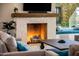 Living room fireplace with white brick surround and wooden mantel at 30508 N 64Th St, Cave Creek, AZ 85331