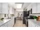 Modern kitchen with white cabinets, stainless steel appliances, and marble countertops at 325 S 74Th Pl, Mesa, AZ 85208