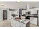 Modern kitchen with white cabinets, island, and stainless steel appliances at 3315 N Datura Ct, Maricopa, AZ 85139