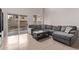 Living room with grey sectional sofa and sliding door access to backyard at 44230 W Palmen Dr, Maricopa, AZ 85138