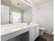 Well-lit bathroom featuring a spacious vanity with countertop, a large mirror, and contemporary fixtures at 44520 W Windrose Dr, Maricopa, AZ 85138