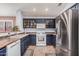 Traditional kitchen with stainless steel refrigerator, dark cabinetry, and white appliances at 44520 W Windrose Dr, Maricopa, AZ 85138