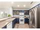 Bright kitchen with stainless steel appliances and dark blue cabinets at 44520 W Windrose Dr, Maricopa, AZ 85138