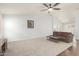 Bright living room featuring neutral carpet and ceiling fan at 44520 W Windrose Dr, Maricopa, AZ 85138