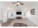 Spacious living room featuring neutral carpet, ceiling fan, and entertainment center at 44520 W Windrose Dr, Maricopa, AZ 85138
