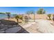 Backyard pool area with decorative rock border, mature palm trees, and patio at 44520 W Windrose Dr, Maricopa, AZ 85138