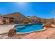Backyard pool featuring a rock surround, brick pavers and partial fencing at 44520 W Windrose Dr, Maricopa, AZ 85138