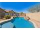 Landscaped backyard featuring a pool, palm trees, and privacy wall, perfect for outdoor living at 44520 W Windrose Dr, Maricopa, AZ 85138