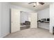 Connected rooms with neutral walls, ceiling fans, carpets, and doorway between spaces at 44520 W Windrose Dr, Maricopa, AZ 85138