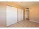 Bedroom with tiled floors, double door closet, and access to hallway at 4613 N 53Rd Dr, Phoenix, AZ 85031