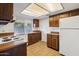 Kitchen with dark wood cabinets and white appliances at 4648 W Continental Dr, Glendale, AZ 85308